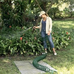 Woman Using Coiled Garden Water Hose